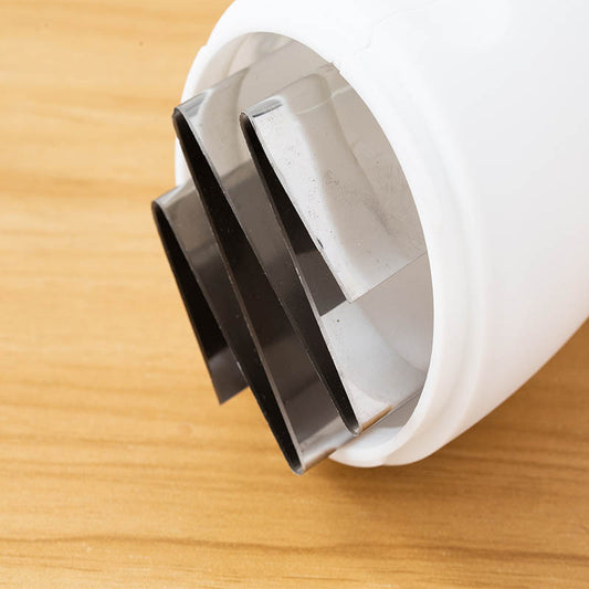 Close-up of a white and black plastic component on a wooden surface