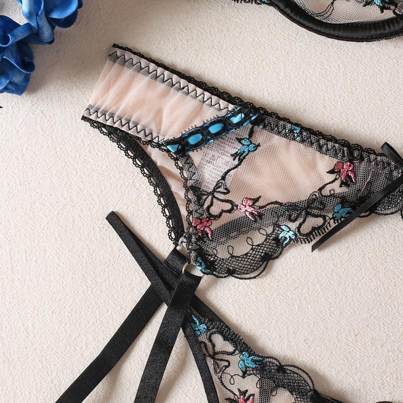 Black lace lingerie set with floral embroidery on a light background