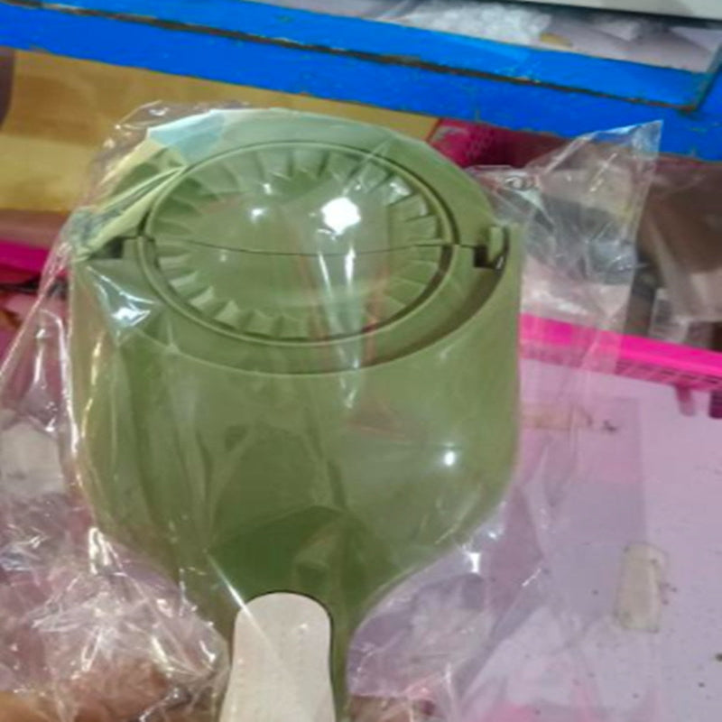 Green kitchen tool with a white handle on a plastic bag background