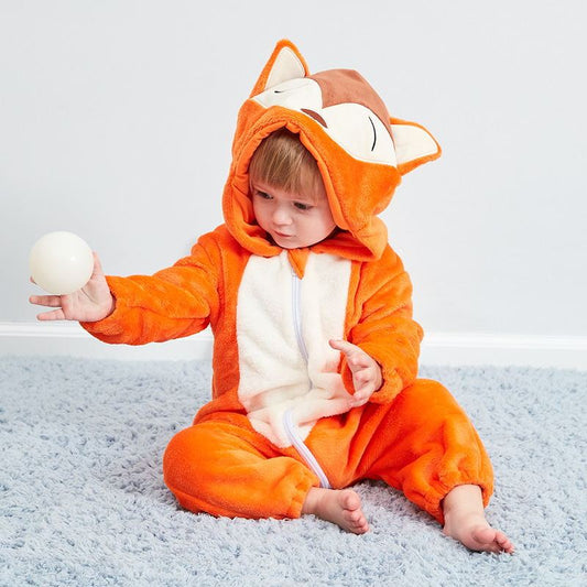Child wearing an orange fox onesie sitting on a gray carpet.