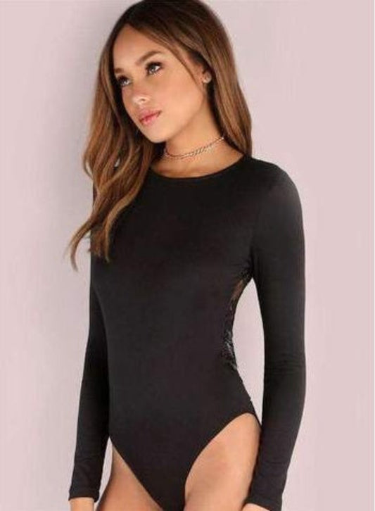 Woman wearing a black long-sleeve bodysuit with a sheer design on a light pink background