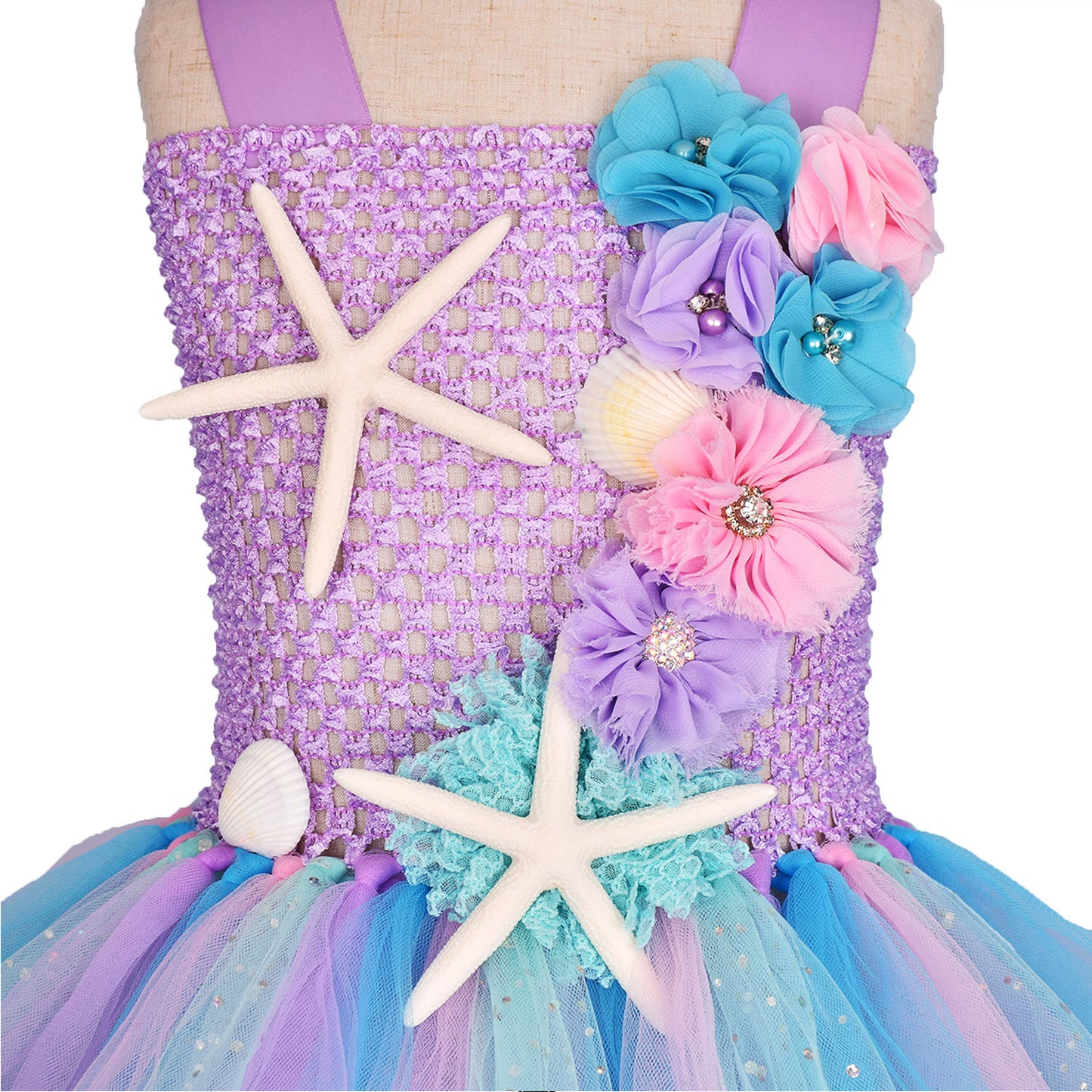 Mermaid-themed dress with flowers, starfish, and a shell on a mannequin.