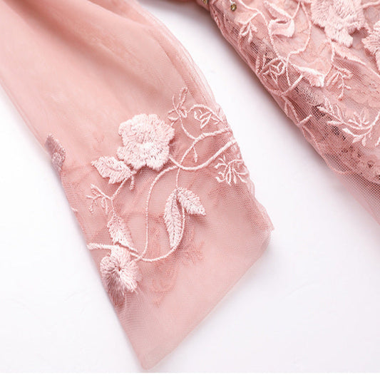 Pink fabric with floral embroidery on a white background