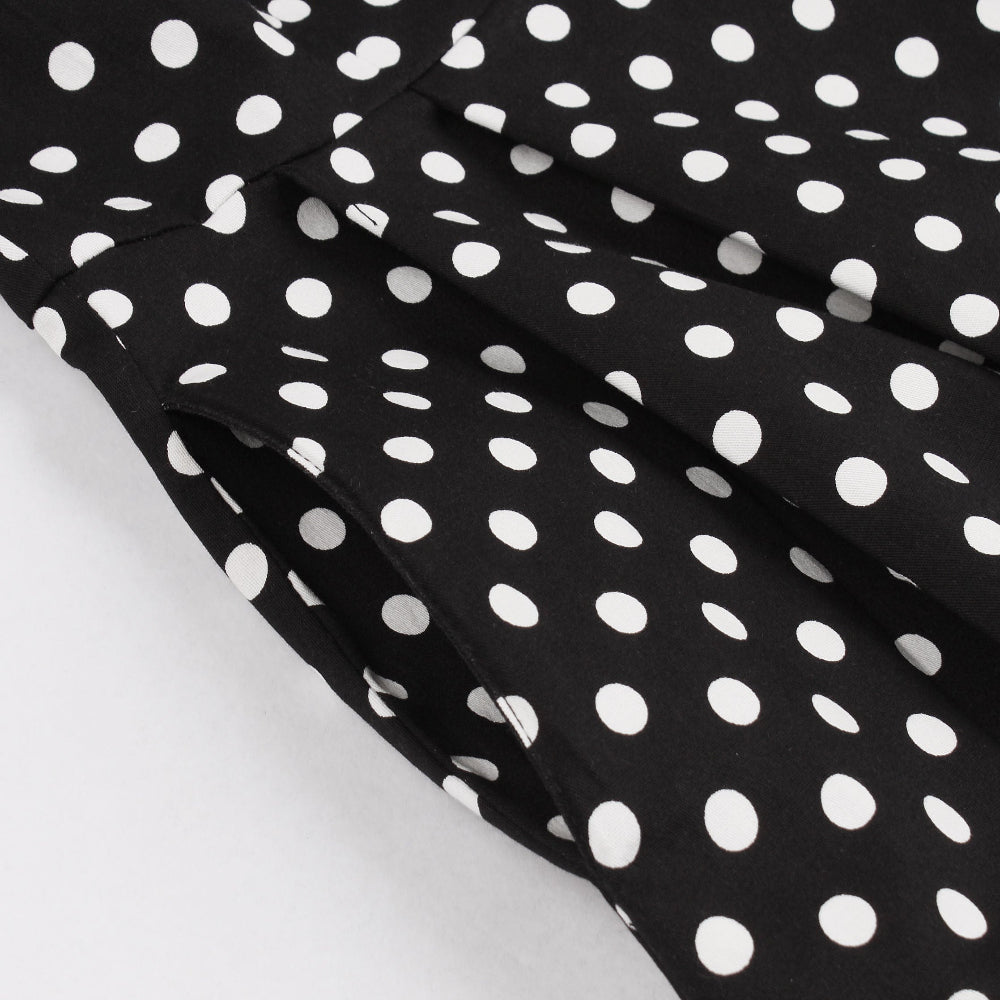 Black fabric with white polka dots on a white background