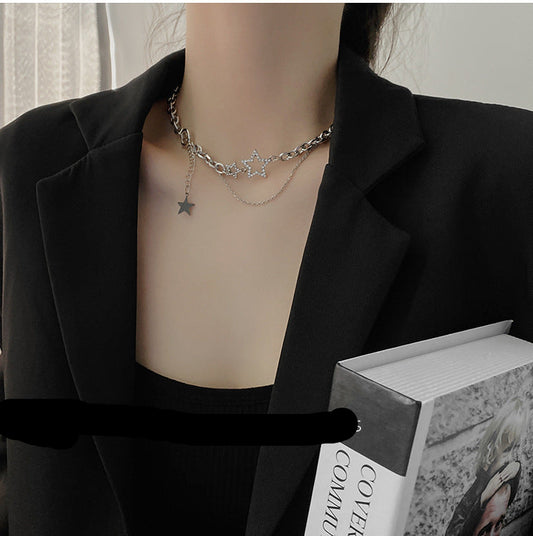 Person wearing a star necklace with a blurred background