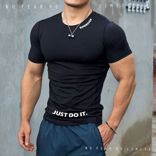 Person wearing a black t-shirt with 'Just Do It' text and blue shorts against a gray background.