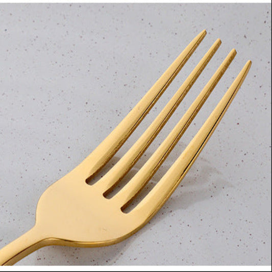 Gold fork on a light gray surface