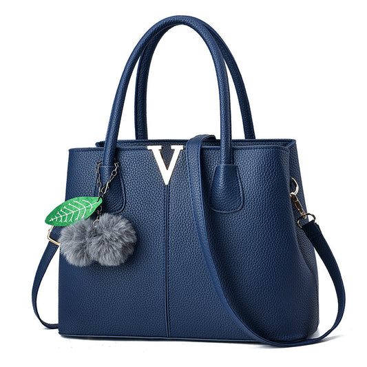 Blue handbag with a decorative charm on a white background