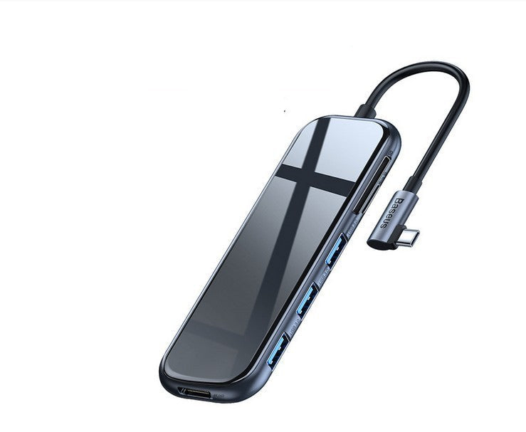 A gray USB-C hub with multiple ports, including USB 3.0 and HDMI, with a black cable attached.