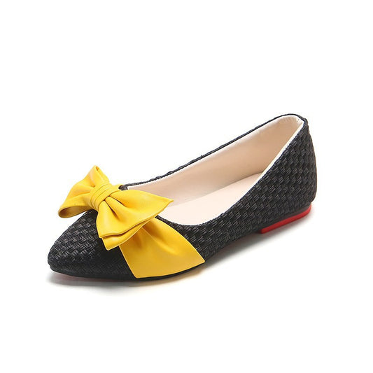 Black flat shoe with a yellow bow on a white background