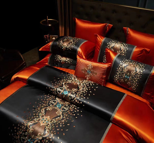 Luxurious bedspread with decorative embroidery and pillows on a bed.