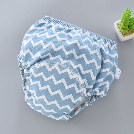 Blue and white zigzag patterned baby bloomers on a gray background
