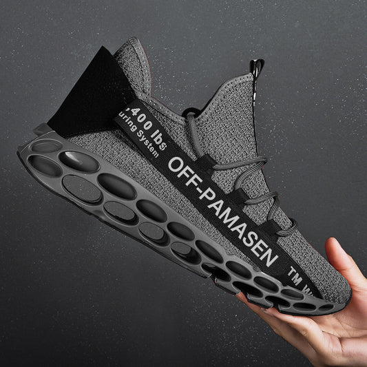 Gray sneaker with unique sole design held by a hand against a dark background