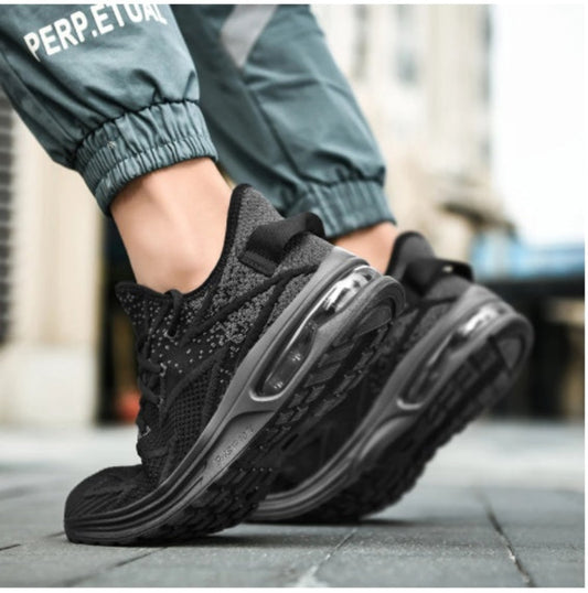 Black athletic shoes worn on a blurred street background