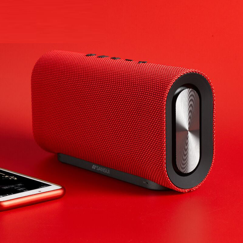 A black wireless Bluetooth speaker with a cylindrical shape and a fabric exterior. It has a silver accent on one end and a control button on the side.