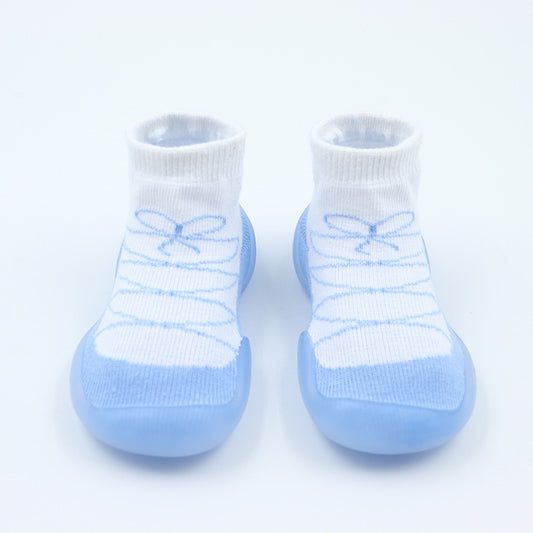 Pair of baby socks with blue soles and white tops on a light gray background