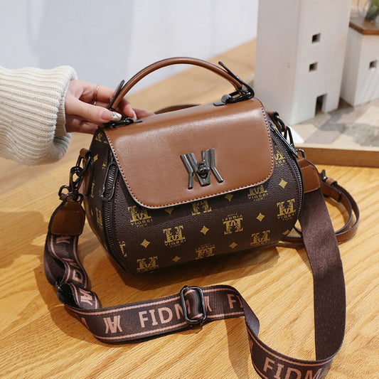 Brown handbag with monogram pattern on a wooden surface