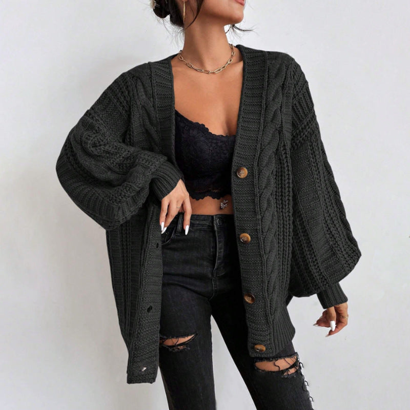 Person wearing a black cardigan over a black bralette and jeans.
