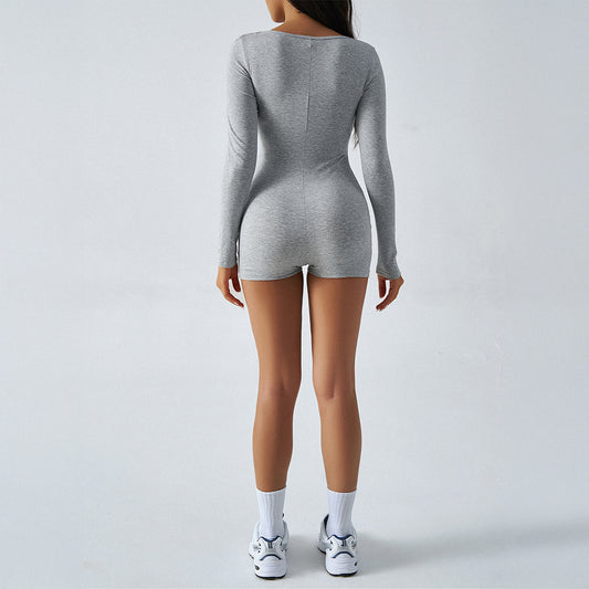 Person wearing a gray long-sleeve top and shorts on a plain background