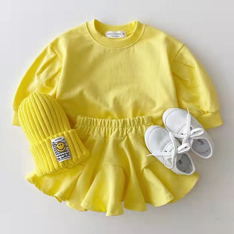 Yellow outfit with a matching hat and white shoes on a light gray background