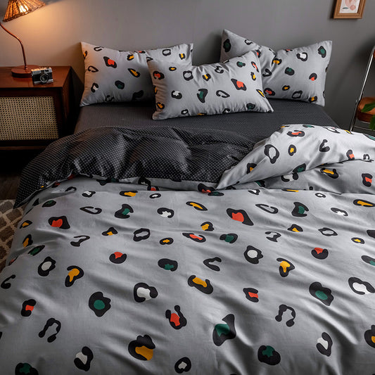 Bed with colorful abstract patterned bedding and pillows in a bedroom setting.