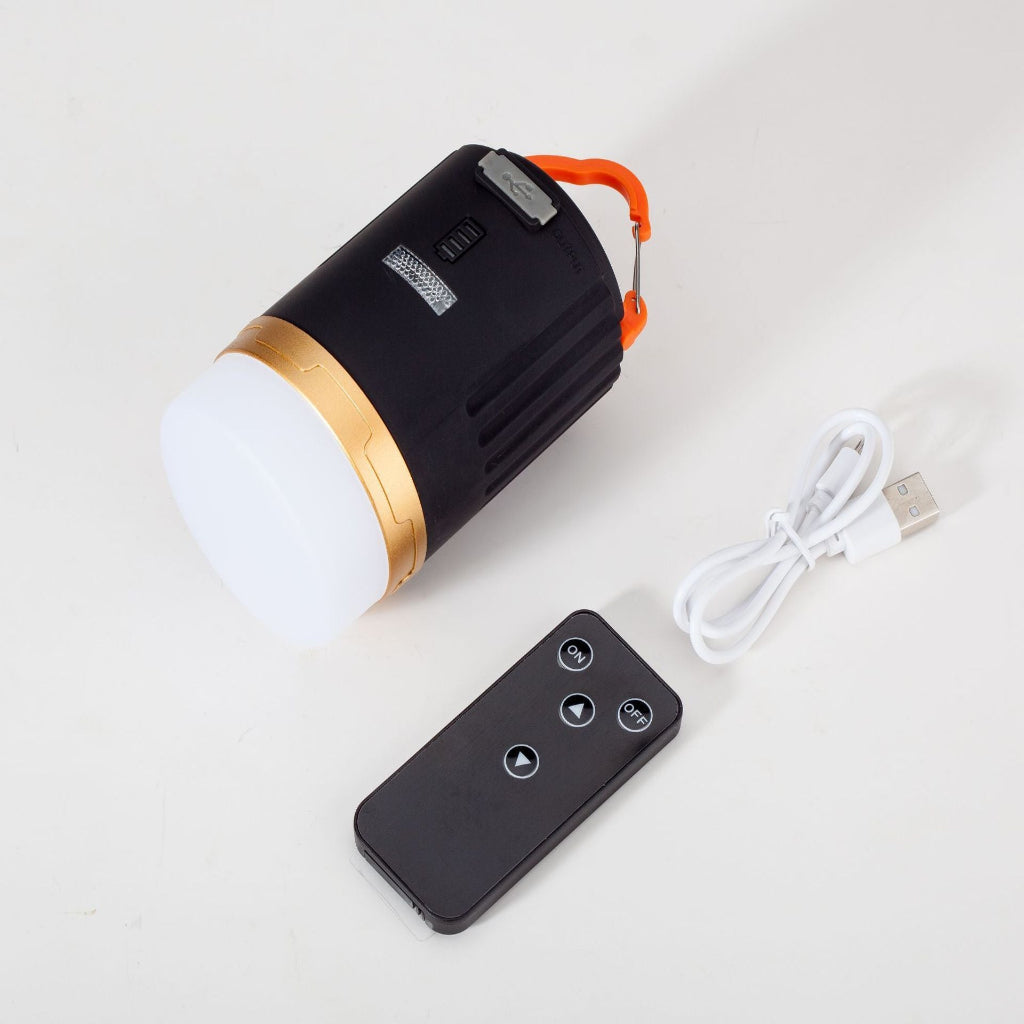 Black and gold portable light with remote control on a white background