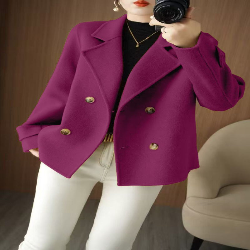 A person wearing a beige knee-length coat with long sleeves and double-breasted button details.