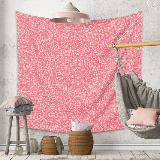 Pink patterned tapestry hanging on a wall with a gray hammock and decorative items below.