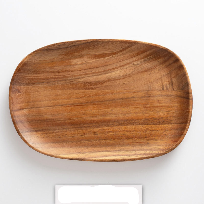A set of irregularly shaped wooden trays in brown color, displayed against a concrete background with a striped patterned fabric to the side.