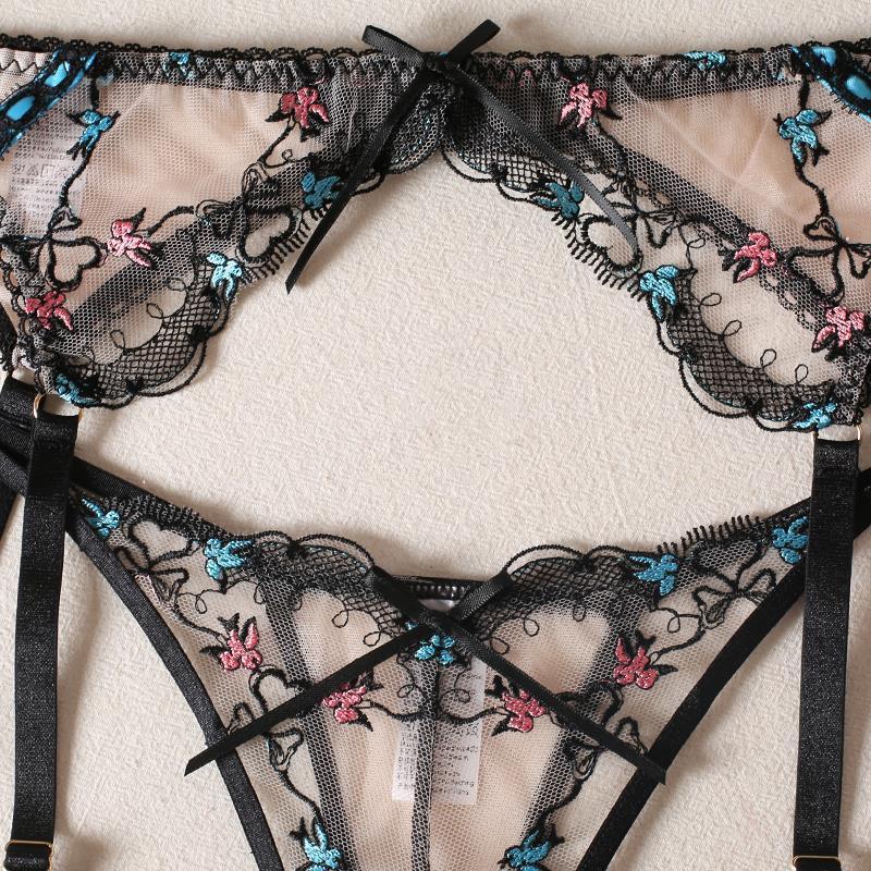 Black lace lingerie set with floral embroidery on a light background