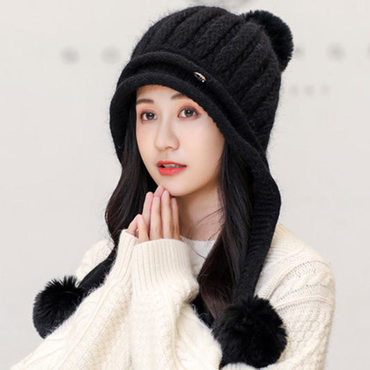 A woman wearing a black striped fleece dome hat with a subtle colorblock pattern.