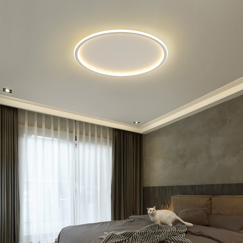 A modern minimalist LED ceiling light with a round shape, emitting a warm white glow, suitable for contemporary interior settings.