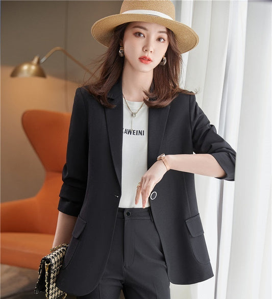 Woman wearing a black blazer coat in an indoor setting