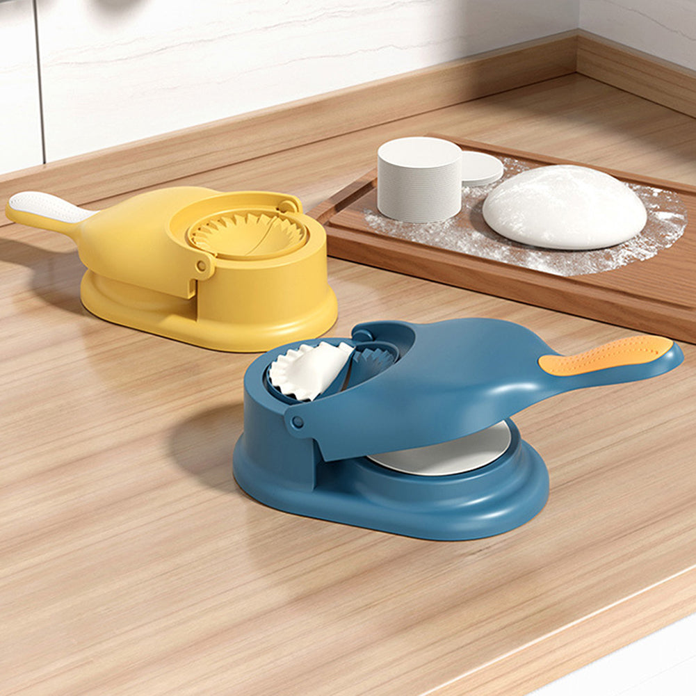 Two kitchen tools, one yellow and one blue, on a wooden surface with white bowls in the background.