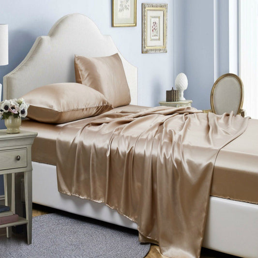 Bed with satin sheets and pillows in a bedroom setting.