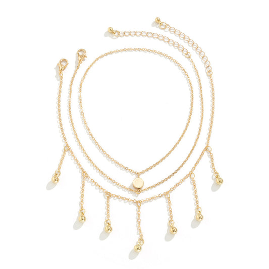 Gold necklaces with dangling elements on a white background