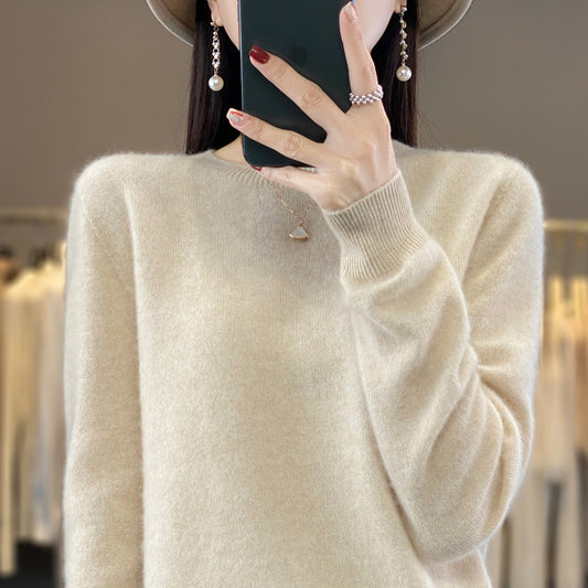 Person wearing a beige sweater holding a phone.