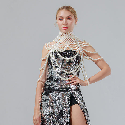 Woman in a silver sequin dress with pearl embellishments on a gray background