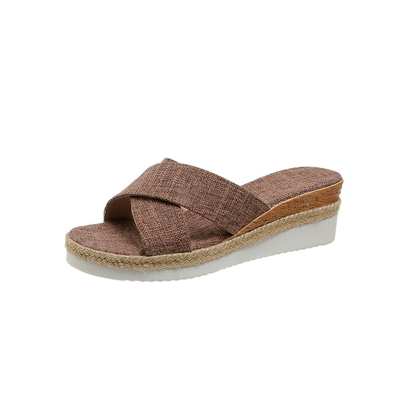 Brown wedge sandal with criss-cross straps on a white background