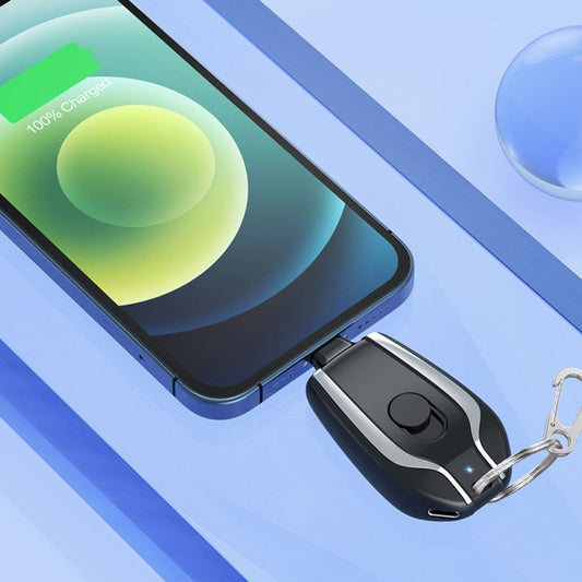 Smartphone with a charging cable and keychain device on a blue background
