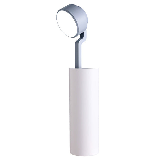Modern floor lamp with a cylindrical base and round adjustable head on a white background