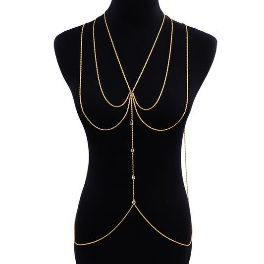 Gold chain body jewelry on a black mannequin.