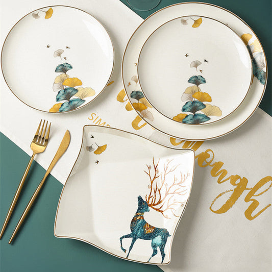 Set of ceramic plates with deer design on a table with cutlery