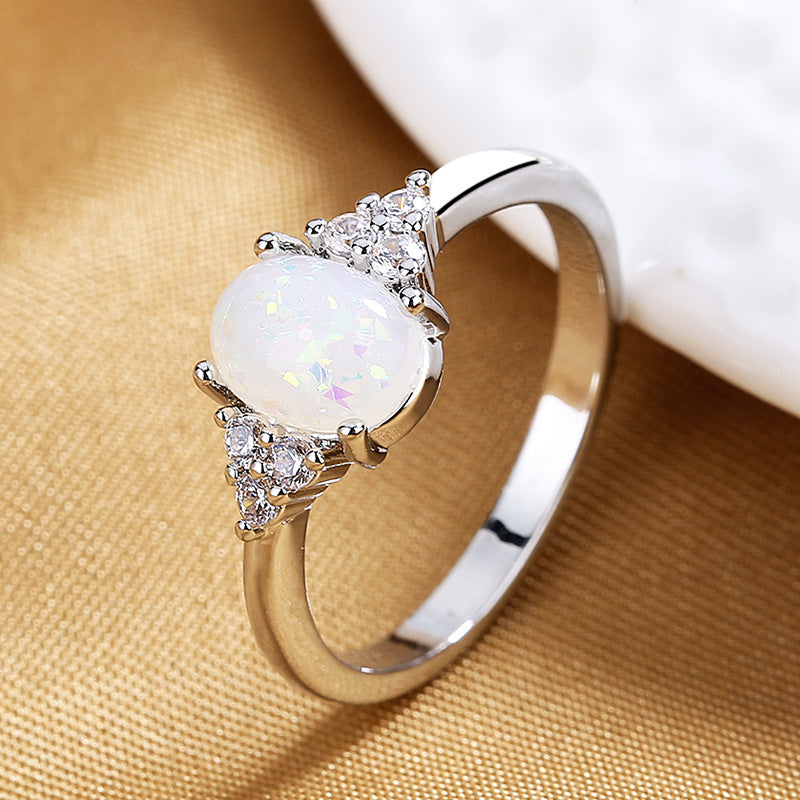 Silver ring with a white gemstone on a beige fabric background