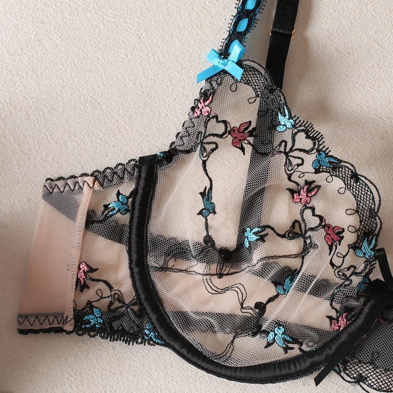 Black lace bra with floral embroidery on a beige background