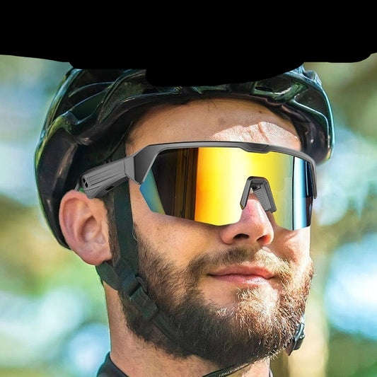 Person wearing a helmet and sunglasses with a soft nose bridge design, set against a blurred natural background.
