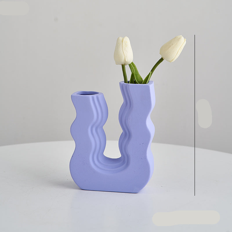 Wavy purple vase with white tulips on a light gray background