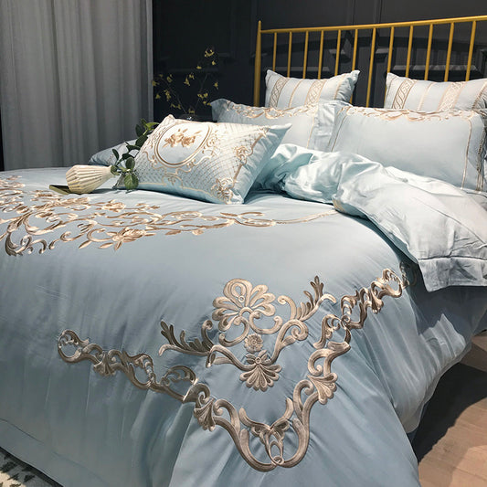 A four-piece bedding set with a duvet cover, sheet, and two pillowcases featuring simple embroidery design, laid out on a bed.