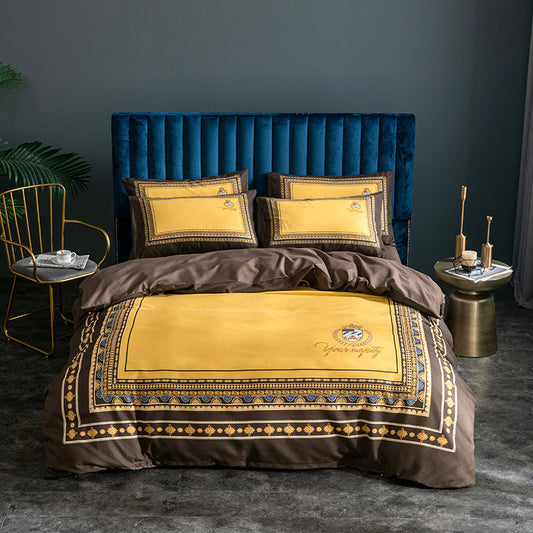 A four-piece bed sheet set in pink with floral patterns, displayed on a bed with a blue headboard, alongside a gold nightstand and a potted plant.