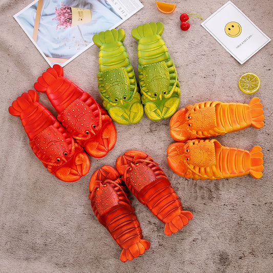 Colorful lobster-shaped slippers on a textured surface with small items around.